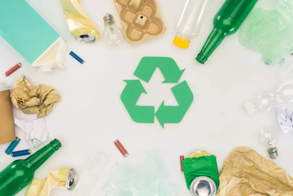 Symbol recyklingu otoczony różnymi frakcjami odpadów